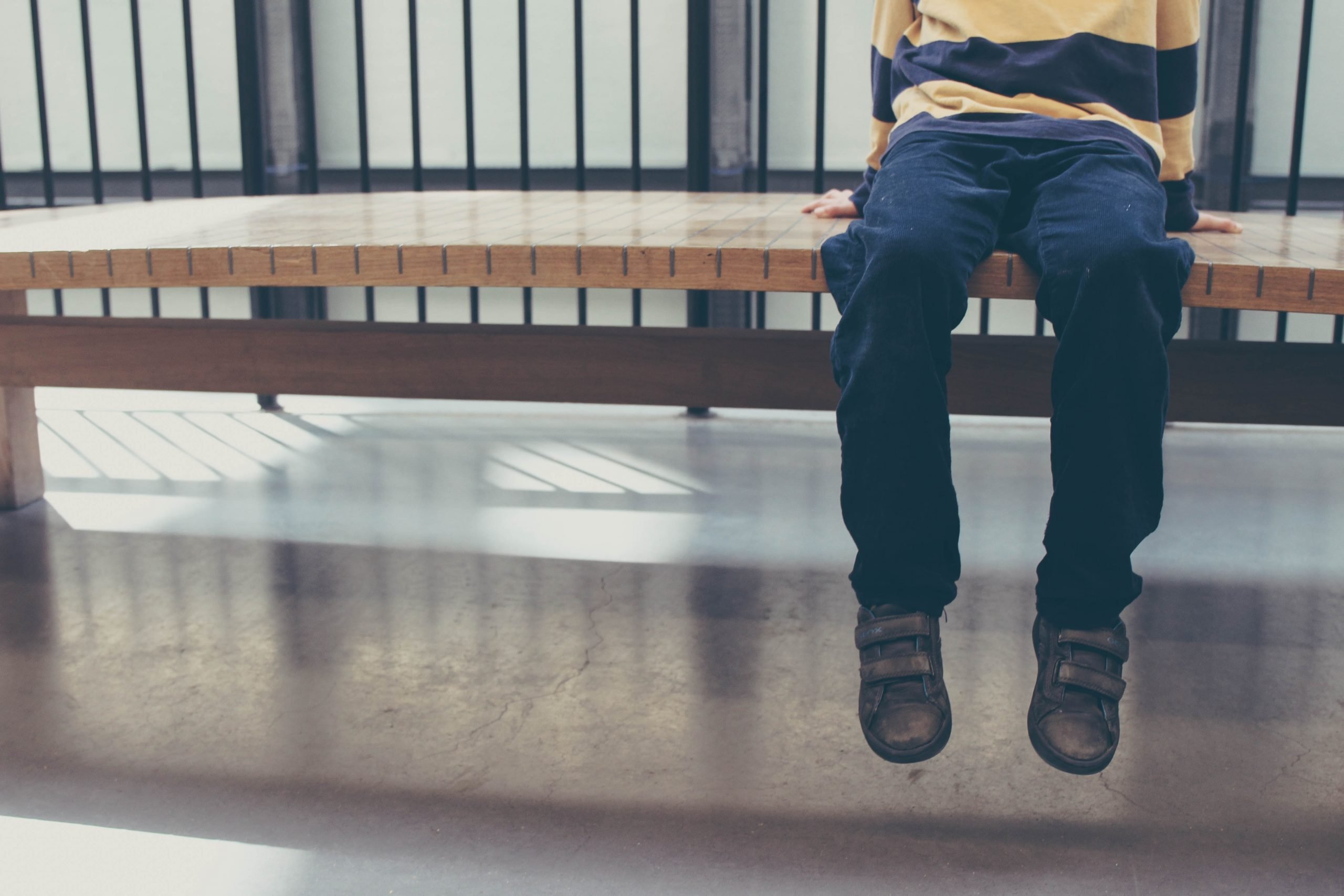 child autism diagnosis_KNR Therapy blog featured image_young boy sitting on a bench
